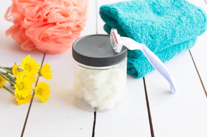glass jar of homemade shaving cream with a razor and towel